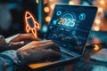 Hands typing on a laptop with a digital display showing 2025 and a rocket icon, symbolizing innovation and future technology Royalty Free Stock Photo